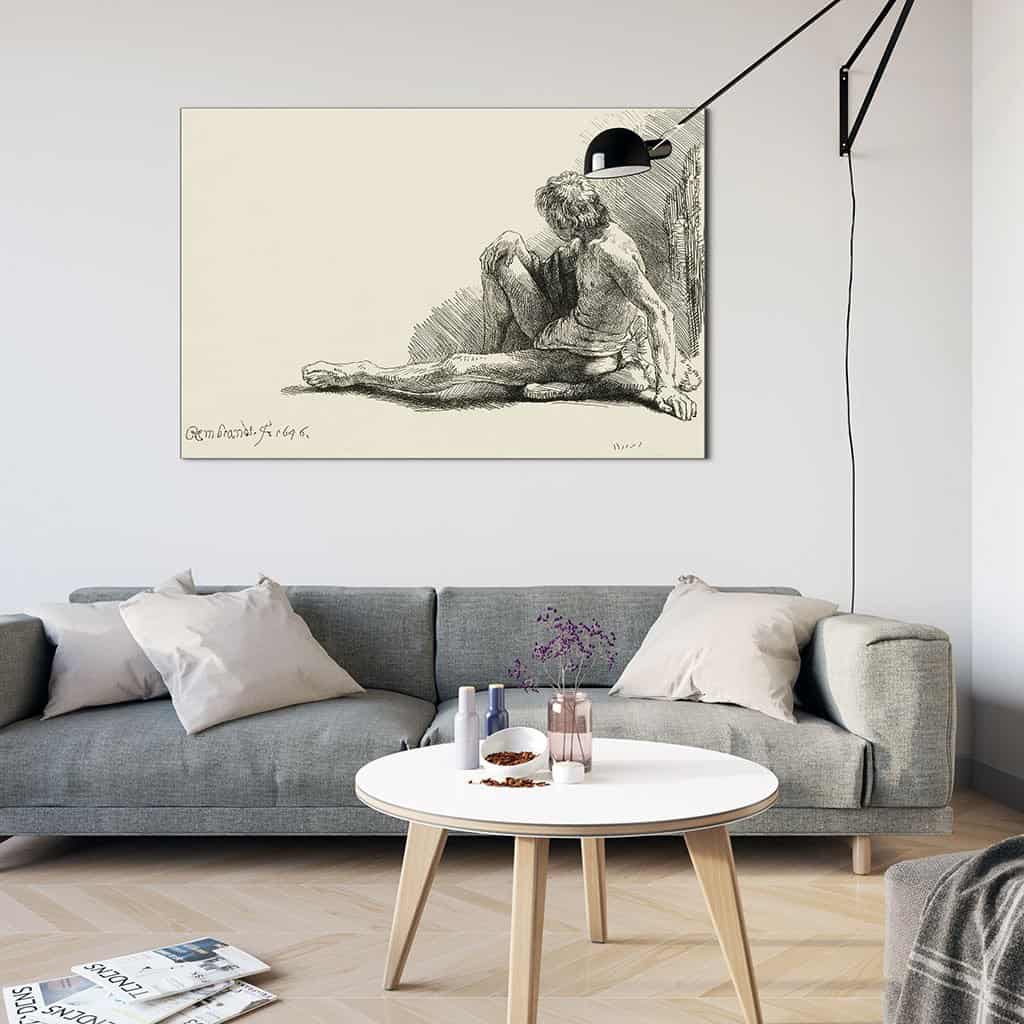 Jonge man, zittend op de vloer met een uitgestrekte been - Rembrandt
