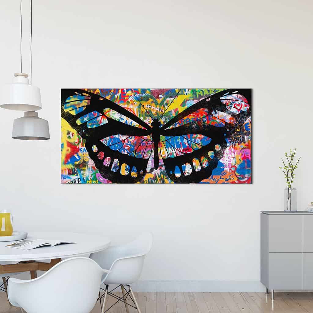 Stencil vlinder op graffiti muur