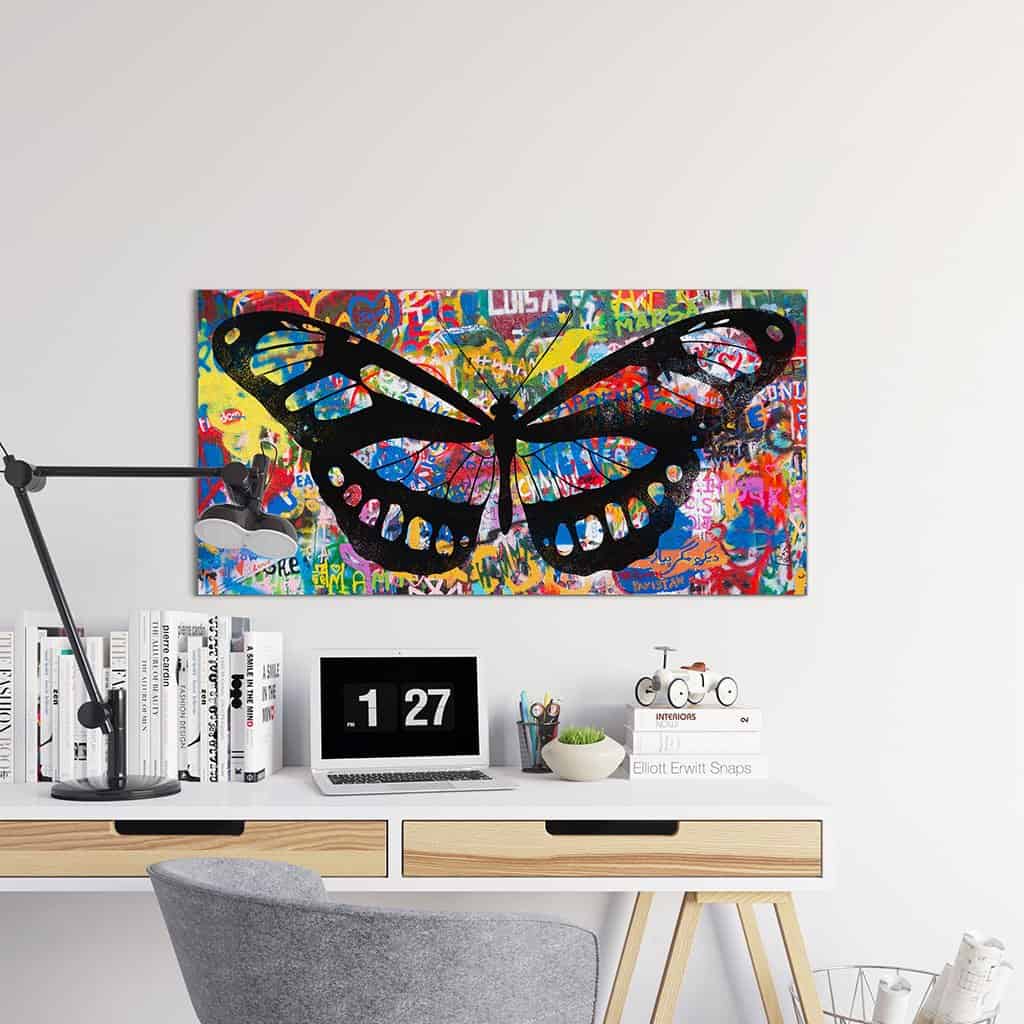 Stencil vlinder op graffiti muur